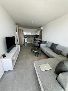 a living room with a couch and a flat screen tv at Modern Designer Home in Larnaka