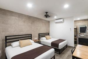 a hotel room with two beds and a sink at Capital Hotel Saltillo in Saltillo