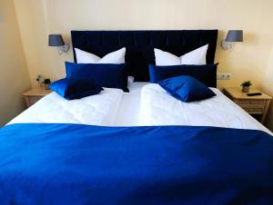 a blue and white bed with blue pillows on it at Doppelzimmer TE01 in Kühlungsborn +7 photos