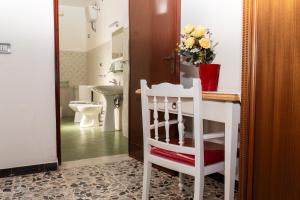 a white bathroom with a white chair and a sink at Pala Cerbu in Mògoro +80 photos