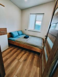 a small bedroom with a bed and a window at Sodyba Miško pakrašty in Gailiūnai