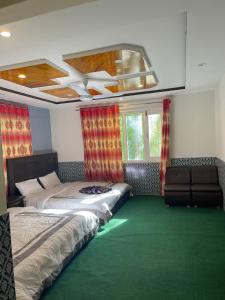 1 Schlafzimmer mit 2 Betten und einem grünen Teppich in der Unterkunft Orophile Nest And Resturent in Skardu
