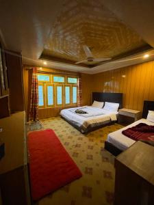 1 Schlafzimmer mit 2 Betten und einem roten Teppich in der Unterkunft Orophile Nest And Resturent in Skardu
