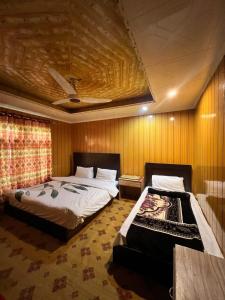 ein Schlafzimmer mit zwei Betten und einer Couch in der Unterkunft Orophile Nest And Resturent in Skardu