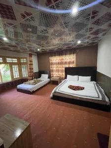 1 Schlafzimmer mit 2 Betten und Kassettendecke in der Unterkunft Orophile Nest And Resturent in Skardu