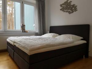 ein Bett in einem Schlafzimmer mit einem großen Fenster in der Unterkunft Zinnowitz Haus Zur Düne in Zinnowitz