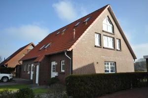 a brown brick house with a red roof at Nr 46 - Ferienhaus Mühlenblick Nähe Museumshafen in Carolinensiel