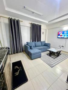 a living room with a blue couch and a table at Elite suite 1bedroom in Busia +6 photos