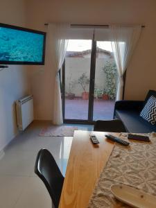 a living room with a wooden table and a large window at Departamento Anita Villa Carlos Paz in Villa Carlos Paz
