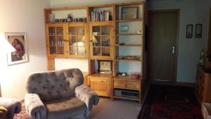 a living room with a chair and a book shelf at Stalu D1 - Bürchen in Bürchen