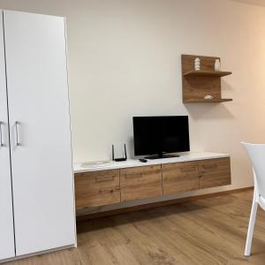 Una sala de estar con un televisor sobre un mueble de madera. en La Torre 9B studio&parking, en Lignano Sabbiadoro