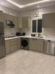 a large kitchen with a washer and a dishwasher at شقة الردف in Taif