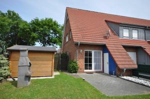 a brick house with a garage and a building at Nr 23 - Ferienhaus Mittelweg in Carolinensiel +12 photos
