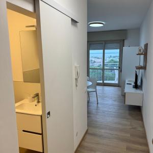 Una cocina con un pasillo con vista a una habitación. en La Torre 9B studio&parking, en Lignano Sabbiadoro