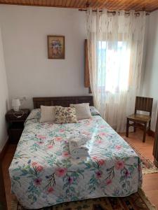 CrecíenteにあるCasa do Carpinteiroのベッドルーム1室(花柄のベッドカバー付)