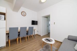 Una cocina y un comedor con mesa y sillas. en Apartment Ren, en Kampor