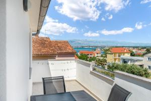 un balcone con sedie e vista sull'acqua di Apartment Baras a Nin