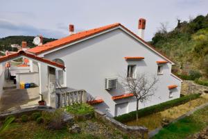 une maison blanche avec un toit orange sur une colline dans l'établissement Apartment Vidas, à Palit