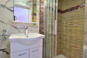 une salle de bain avec un lavabo blanc et une douche dans l'établissement Apartment Vidas, à Palit 29 autres photos