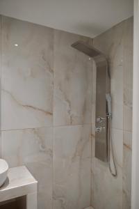 a shower with a glass door in a bathroom at Rastoni Apartments Skiathos in Troulos