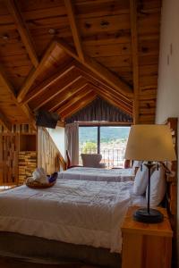 a bedroom with a large bed and a large window at Hotel Quinta los Morales in San Cristóbal de Las Casas