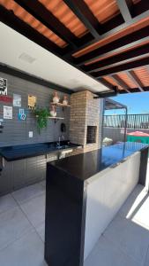 Una cocina con encimera negra en una habitación. en Flat Intermares, en Cabedelo