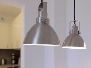 two lights hanging from a wall in a kitchen at Ohlerich Speicher App_ 05 in Wismar