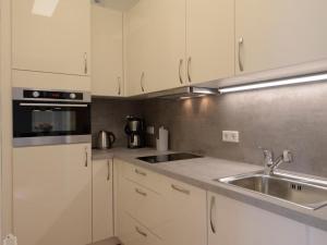 a kitchen with white cabinets and a sink at Ohlerich Speicher App_ 05 in Wismar +15 photos