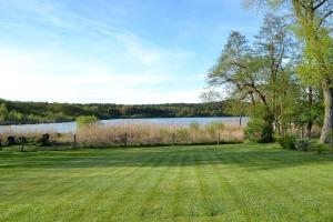 滨湖克拉科Ferienhaus am See auf großem Grundstück, Kaminofen的一片大草场,后面有湖泊 更多19张照片