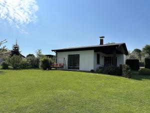 滨湖克拉科Ferienhaus am See auf großem Grundstück, Kaminofen的一座白色的小房子,有大草地庭院