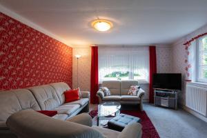 a living room with two couches and a television at Ferienwohnung Mientje, 35214 in Hesel