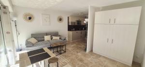 un salon avec un canapé et une table dans l'établissement Studio cabine moderne design avec vu sur jardin , piscine, à La Grande Motte