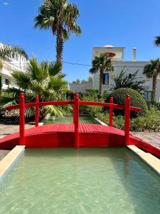 a red bridge over a pool of water at Asilah VIP - Sea view & Swimming Pools - Garage Private in Asilah