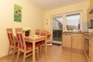 a kitchen and dining room with a table and chairs at Ferienwohnung Plogmann - Residenz Bernstein WHG 39 in Rerik +9 photos