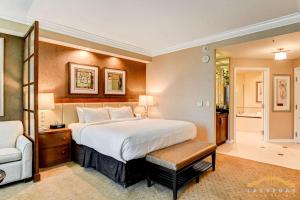 a hotel room with a large bed and a chair at MGM Signature-07-703 Strip View Jacuzzi Studio in Las Vegas +40 photos
