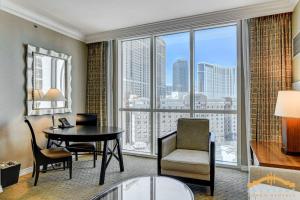 a living room with a desk and chair and a large window at MGM Signature-07-703 Strip View Jacuzzi Studio in Las Vegas
