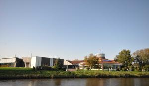 a building next to a body of water at Nr 05 - Ferienhaus Mühlenblick Nähe Museumshafen in Carolinensiel