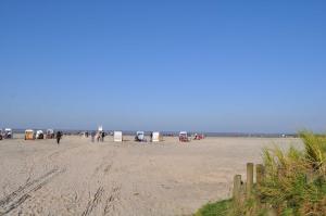 a group of people walking on the beach at Nr 05 - Ferienhaus Mühlenblick Nähe Museumshafen in Carolinensiel
