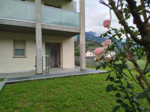 a view of a building with pink roses in a yard at Garden House in Sondrio