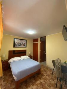 a bedroom with a bed and a desk with a computer at LA FAMILIA NASCA HOUSE in Nazca