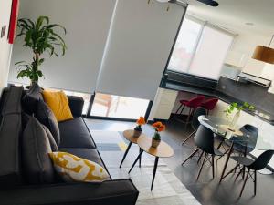 a living room with a couch and a table at Northtown San Ramón in Mérida +2 photos