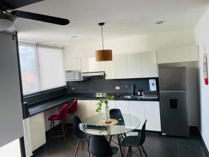 a kitchen with a table and some chairs and a table and a counter at Northtown San Ramón in Mérida
