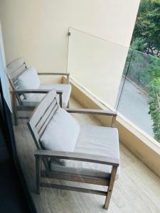 two chairs sitting in a room with a window at Northtown San Ramón in Mérida