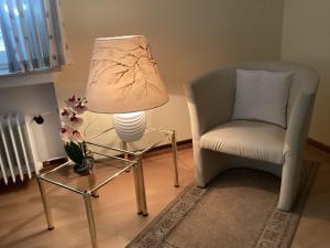a lamp and a chair in a living room at Ferienwohnung Krapohl in Bad Harzburg