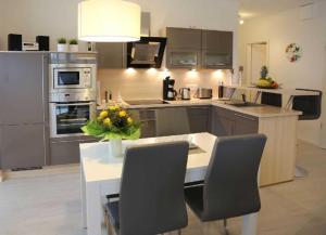 a kitchen with a table with a vase of flowers on it at Exkl App Silbermöwe, 100 m zum Strand mit WLAN in Börgerende-Rethwisch