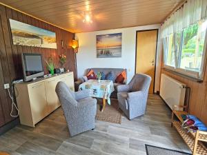 a living room with a table and chairs and a television at Ferienhaus am Wiesengrund in Sagard