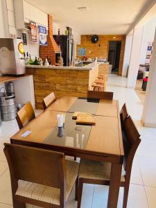 a dining room table with chairs and a kitchen at Pousada 4 Estações in Botucatu +38 photos