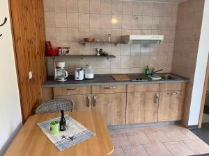a small kitchen with a wooden table and a sink at Ferienunterkuenfte Feldmann in Korswandt +18 photos