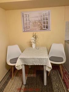 a table and two chairs with a table and a picture at Ferienwohnung R Packmohr in Ueckeritz