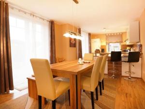 a kitchen and dining room with a wooden table and chairs at Schwannest 1 in Groß Schwansee +17 photos